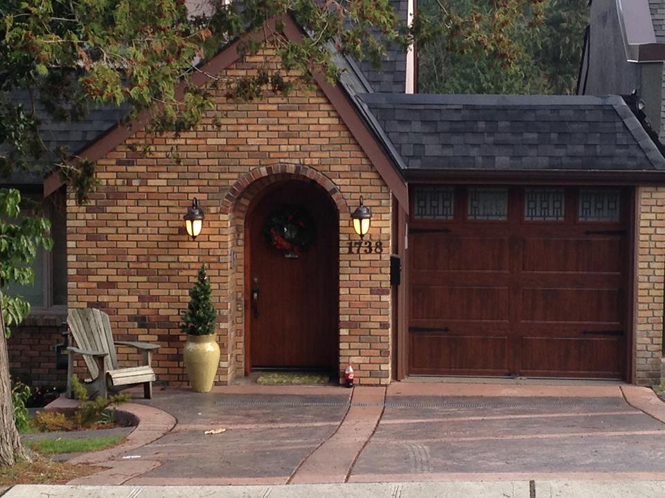 dark wood-look garage doors with entry door